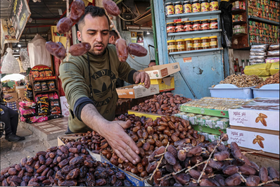  فروشنده فلسطینی در خان‌یونس نوار غزه در حال فروش خرما